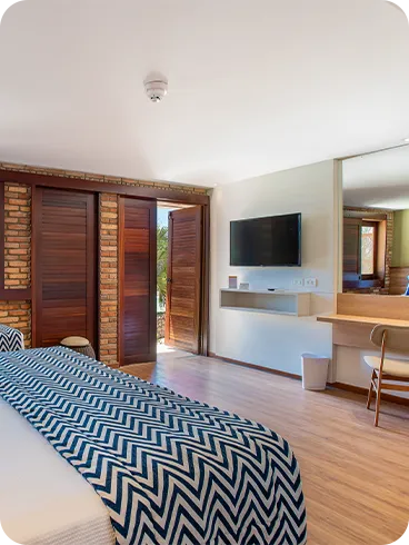 Parte de la Suite Familia, uno de los alojamientos en Salinas Maragogi, con una cama queen y una cama individual, lámparas, un marco decorativo de madera con fotografías de las playas de Maragogi y una pared de ladrillo.
