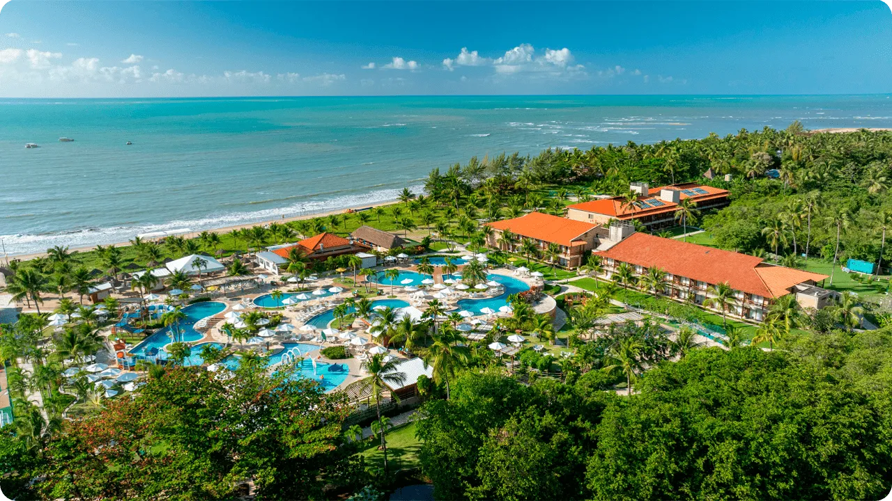Vista panorâmica da estrutura do resort Salinas Maragogi, mostrando piscinas, jardim e a praia