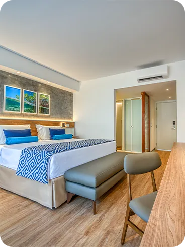 Detalles del área principal del alojamiento Standard Vitória-Régia, con cama queen-size y cama individual, mesa y silla, panel con TV por cable, espejo redondo con iluminación, decoración acogedora y balcón con hamaca. El apartamento tiene vista al jardín.