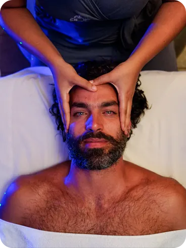 Man lying on stretcher at the Salinas Maragogi spa, receiving massage on my head.