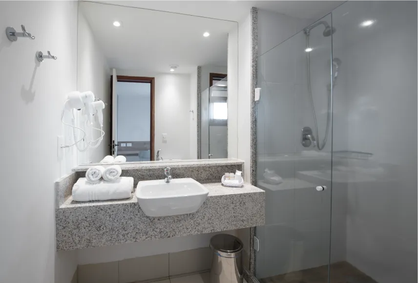 Baño de acomodación estándar, con lugar para baño, instalaciones sanitárias, ducha con reglaje de temperatura, decoración, amenidades, toallas, grande espejo y secador de pelo.