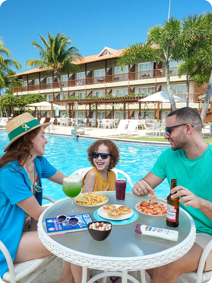 Família se divertindo na área da piscina, com drinks, petiscos e clima ensolarado