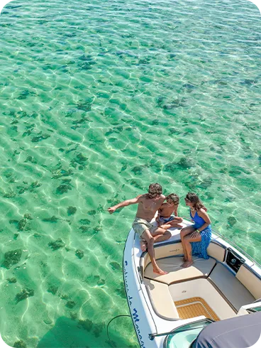 Família aproveitando passeio de lancha sobre águas cristalinas nas piscinas naturais de Maragogi, cenário paradisíaco ideal para turismo em família no litoral de Alagoas.
