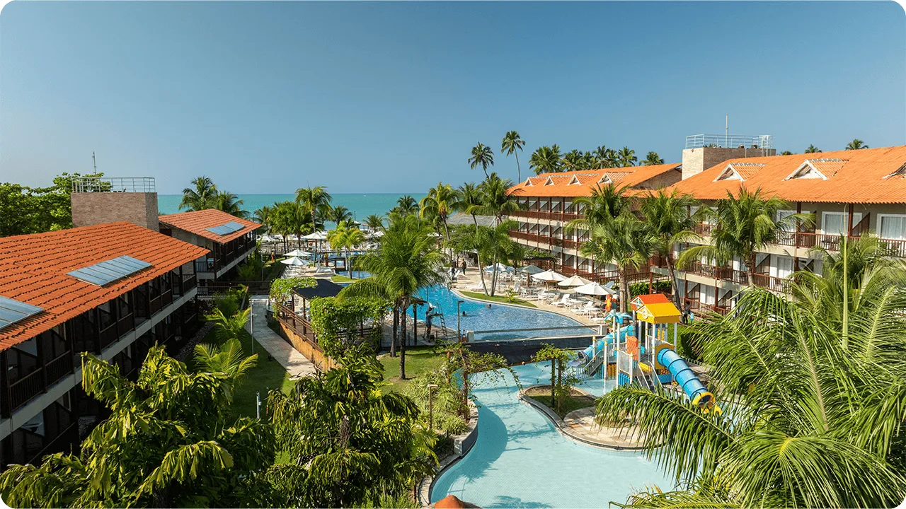 Family playing in the resort's pool with a colorful slide.