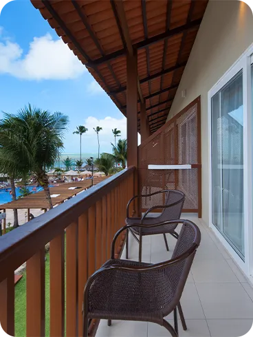 Deluxe room balcony, with two chairs and a pool view.