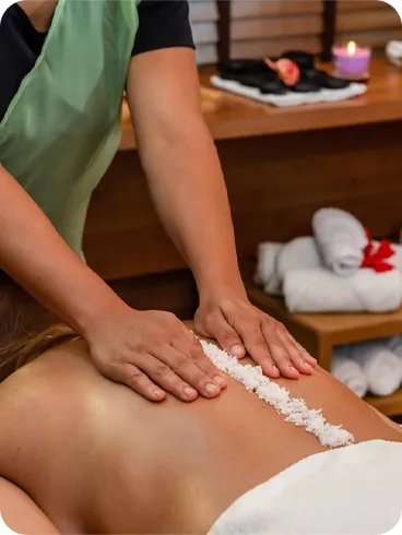 Mulher recebendo massagem com sal marinho relaxante no spa.