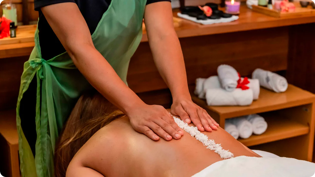 Mulher recebendo massagem com sal marinho relaxante no spa.