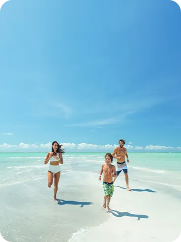 Família correndo e se divertindo em um banco de areia na Praia de Antunes, em Maragogi, Alagoas. Mar com águas cristalinas e paisagem paradisíaca