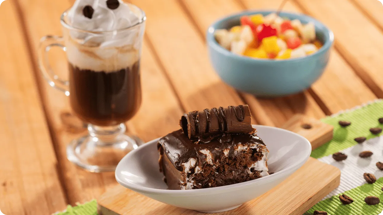 Brownie de chocolate servido com café cremoso e salada de frutas no resort All Inclusive