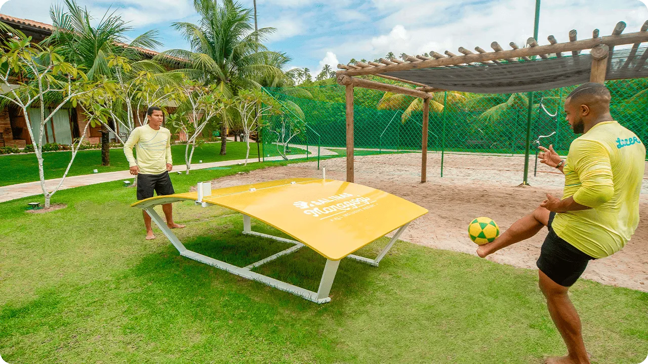 Two men playing table football in an outdoor area in Salinas Maragogi