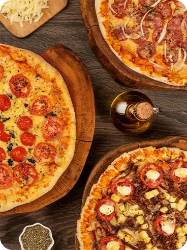 Diferentes sabores de pizza, incluindo opções salgadas e doce, servidas no sistema All Inclusive
