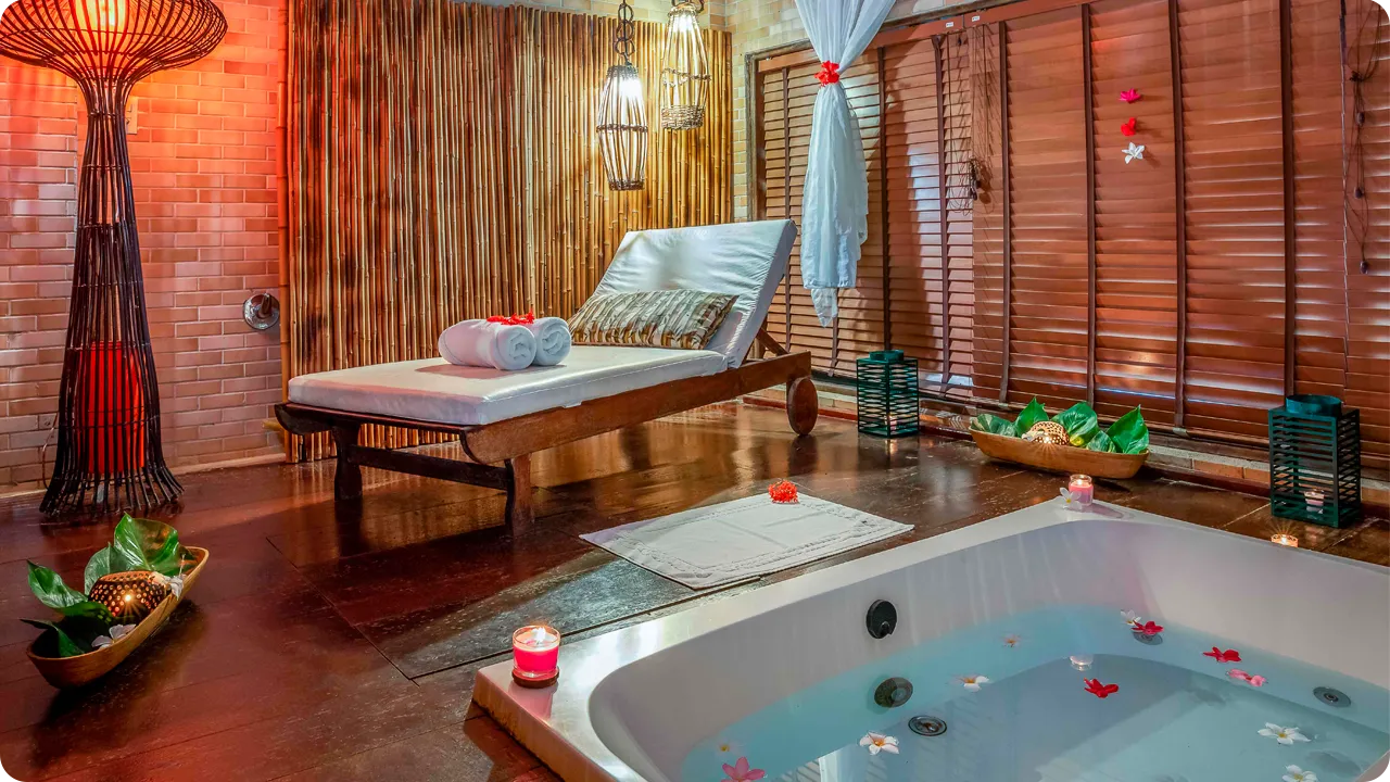 Spa com banheira de hidromassagem e ambiente decorado com velas e flores