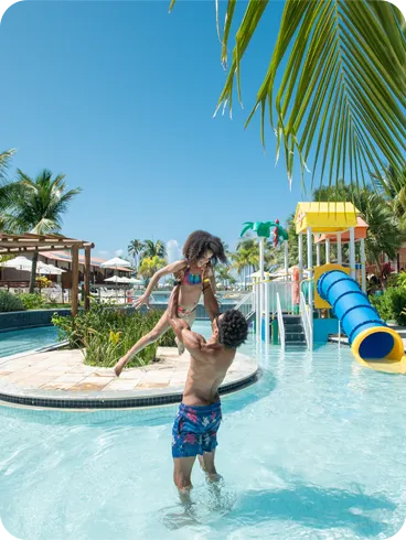 Pai brincando com filha na piscina infantil do resort