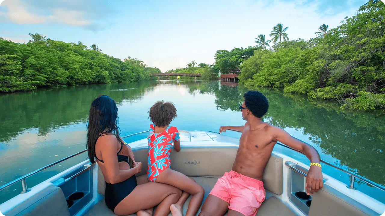 Família aproveitando passeio de lancha pelo rio Maragogi, admirando a paisagem natural.