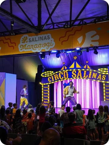 Crianças assistindo a uma apresentação de palhaços no espetáculo “Circo Salinas” dentro do resort.