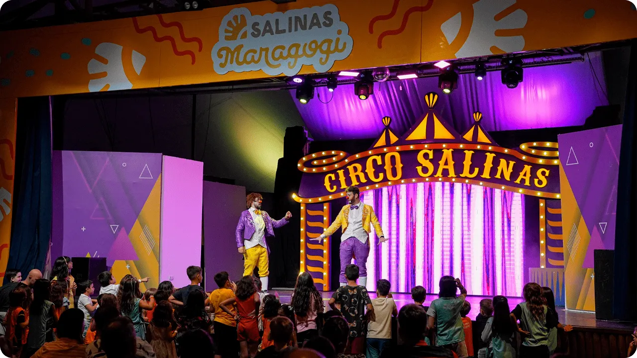 Crianças assistindo a uma apresentação de palhaços no espetáculo “Circo Salinas” dentro do resort.