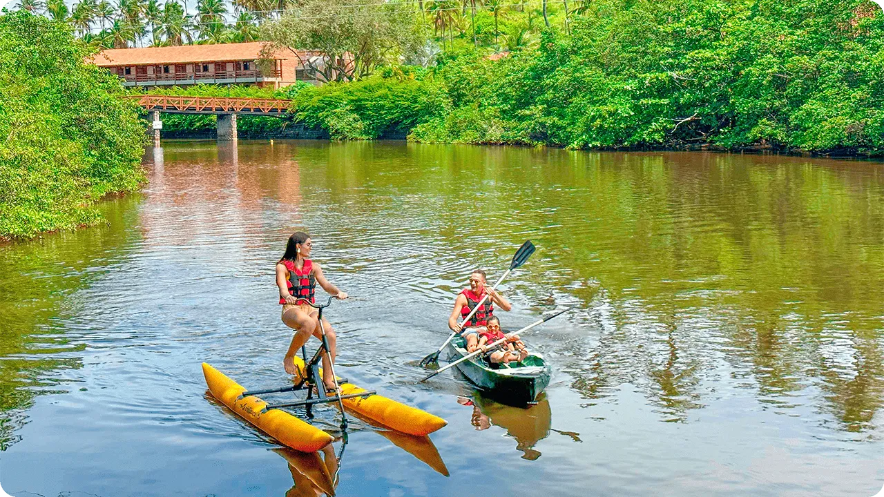 Family enjoying water activities with kayaking and pedal boating on the Maragogi River