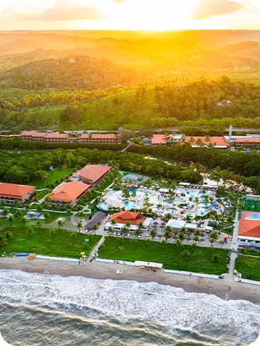 Vista aérea do resort Salinas Maragogi ao entardecer com vista para o mar.