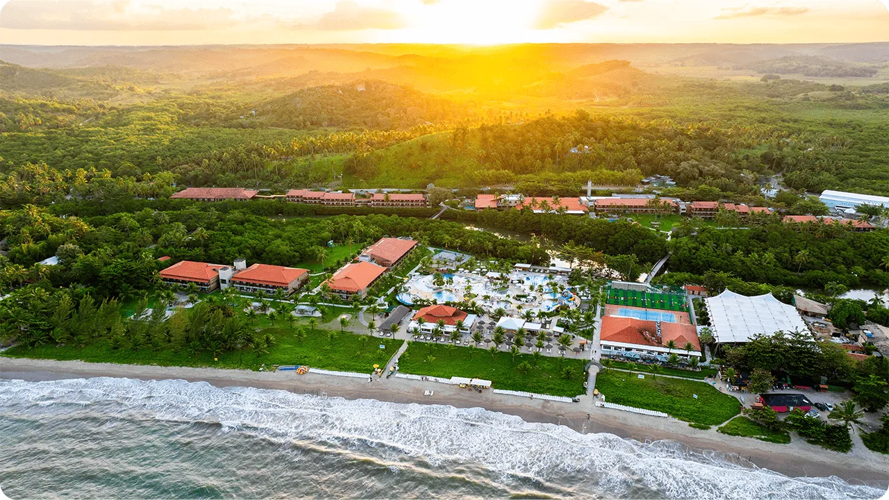 Vista aérea do resort Salinas Maragogi ao entardecer com vista para o mar.