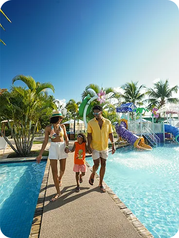 Family walking next to the water park with colorful slides at Salinas Maragogi