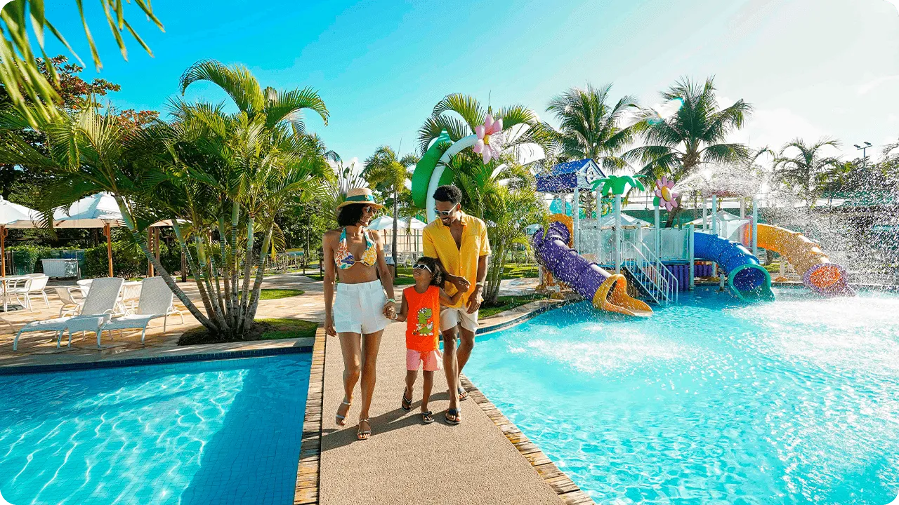 Family walking next to the water park with colorful slides at Salinas Maragogi