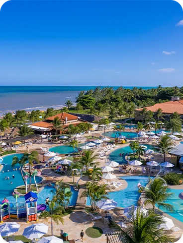 Aerial view of the beachfront Salinas Maragogi resort with pools, a children's area, and coconut trees.