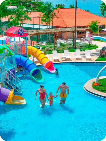 Family playing in the water park with colorful slides at Salinas Maragogi