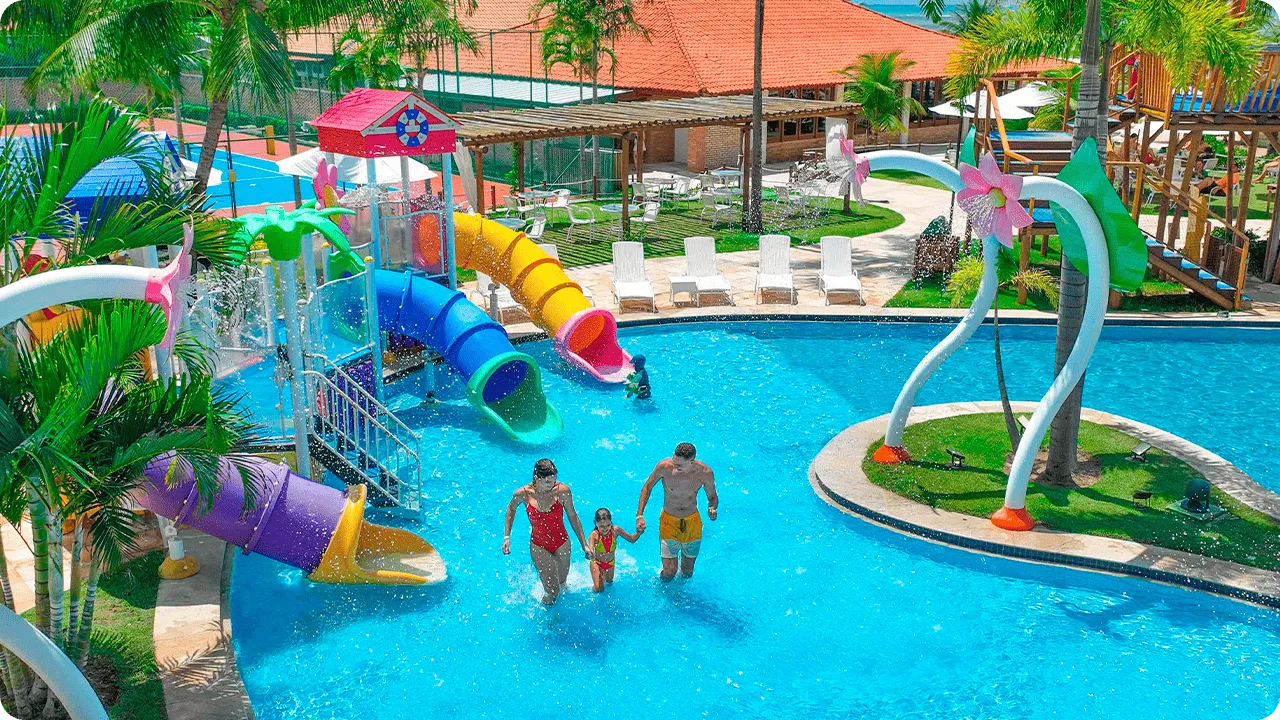 Family playing in the water park with colorful slides at Salinas Maragogi