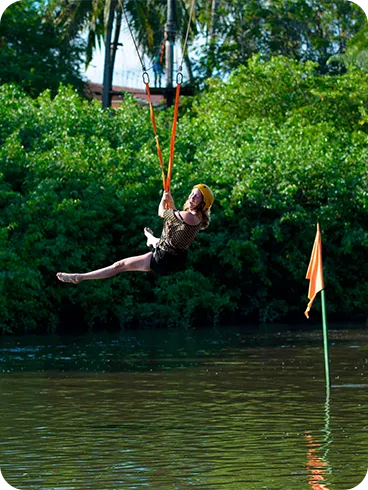 Woman having fun on the zipline over the Maragogi River