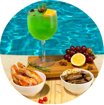 Almoço leve e petiscos com camarões, carne grelhada, frutas e drink tropical à beira da piscina.