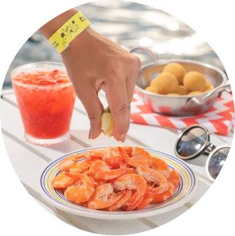 Petiscos tropicais com camarões, bolinhos fritos, drinks coloridos e limão espremido à beira da piscina.