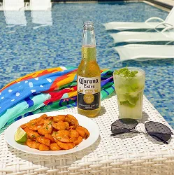 Mesa à beira da praia com camarões, cerveja Corona e caipirinha com vista pra piscina do resort Salinas Maceió