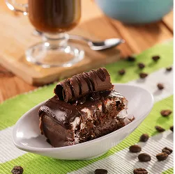 Taça de café com chantilly ao lado de bolo de chocolate e tigela de frutas