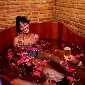 Woman relaxing, lying on a table, with hot stones placed side by side on her back.