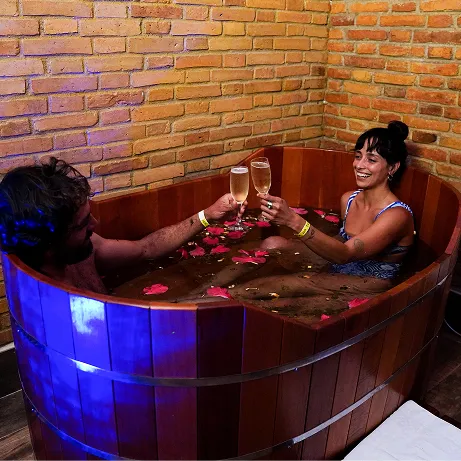 Woman relaxing, lying on a table, with hot stones placed side by side on her back.