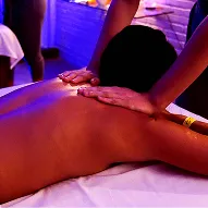 A man and a woman lying on a table at the spa, receiving a neck massage during a romantic ritual.