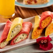 Crepiocas coloridas recheadas acompanhadas de suco de laranja