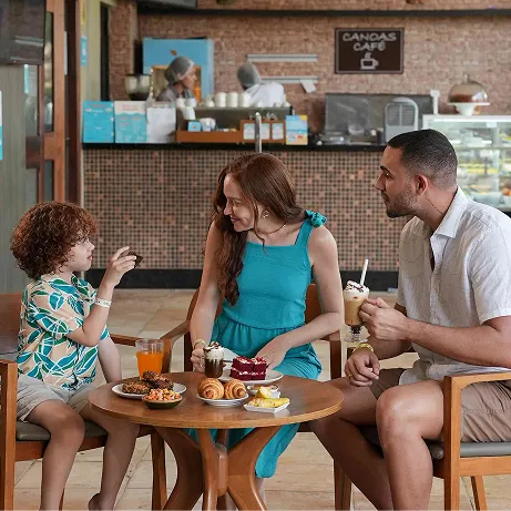 Família aproveitando sobremesas e bebidas no café do resort
