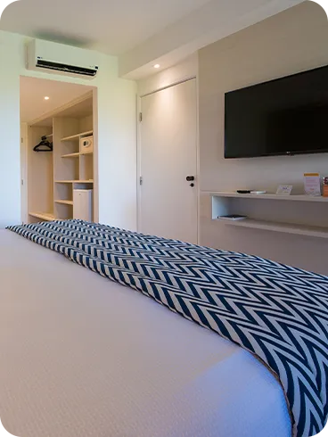 Uma cama queen size no apartamento Standard, televisão, ar-condicionado e roupeiro.