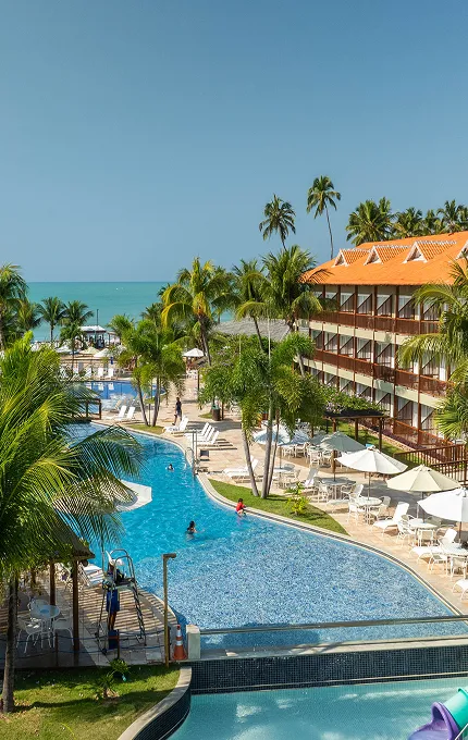 Vista aérea da estrutura do Salinas Maceió All inclusive Resort à beira-mar da praia de Ipioca, com piscinas, pontos de consumo, áreas de lazer e acomodações.