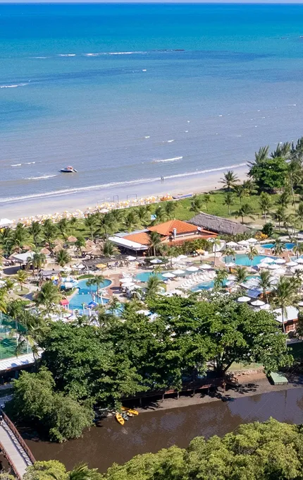 Vista aérea da estrutura completa do Salinas Maragogi All inclusive Resort à beira-mar da praia de Maragogi e cortado pelo Rio Maragogi, com piscinas, pontos de consumo, áreas de lazer e acomodações.