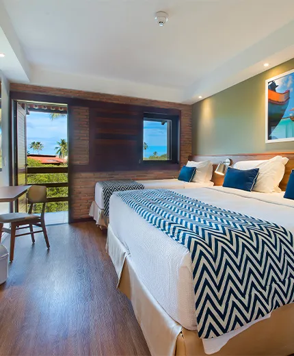 Interior del apartamento estándar en el Salinas Maragogi All Inclusive Resort, con una cama queen y una cama individual.