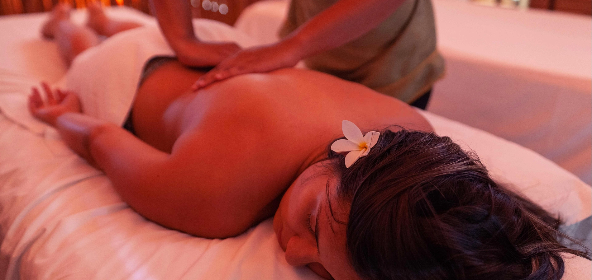 Mulher deitada recebendo uma massagem relaxante em spa.