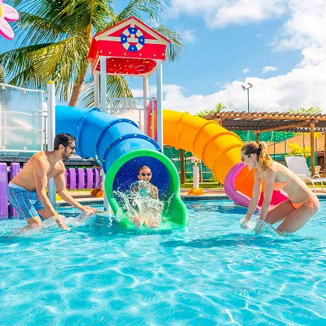 Família se divertindo no parque aquático do Resort Salinas Maragogi, com escorregador e brinquedos coloridos