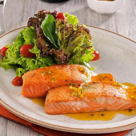 Prato de salmão acompanhado de salada e espumante como parte da oferta do resort all inclusive