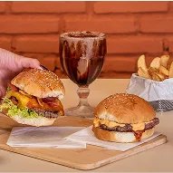 Hambúrguer artesanal com batata frita, molhos e milkshake de chocolate sobremesa com fundo de tijolos