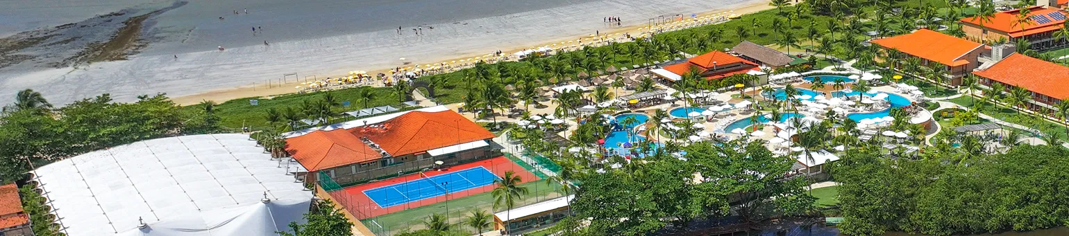 Vista aérea do resort Salinas Maragogi com piscinas, quadras esportivas e praia ao fundo