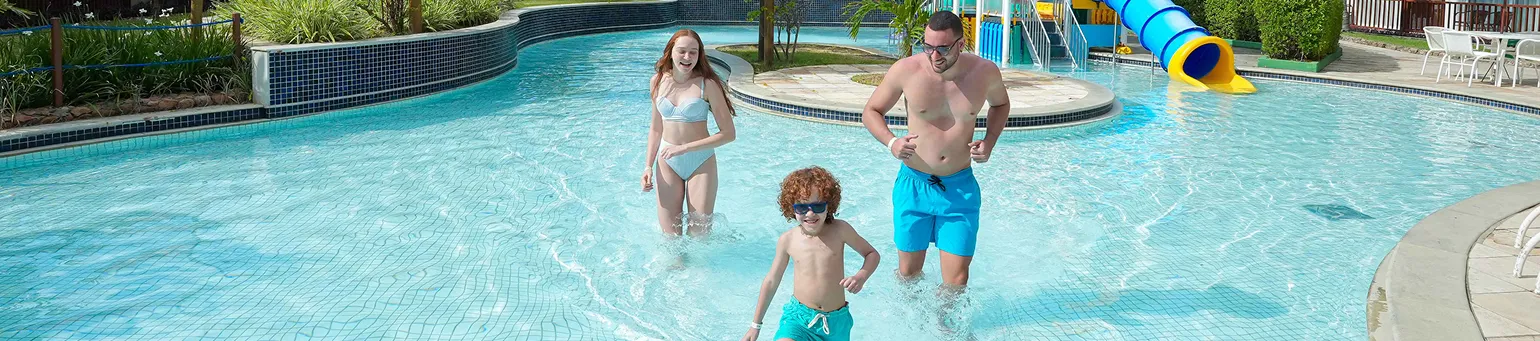 Família feliz brinca na piscina infantil no Salinas Maceió.