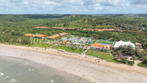 Vista aérea do Salinas Maragogi, possível ver todo a estrutura do resort de frente pro mar com maré baixa. Complexo de piscinas e pontos de consumo tudo cercado por vegetação.