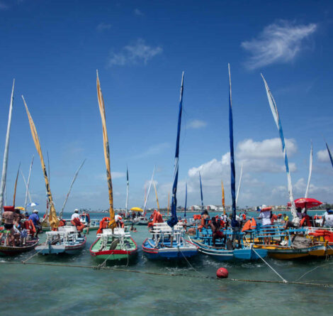Diversos barcos enfileirados na água, representando ponto de passeios de barcos.